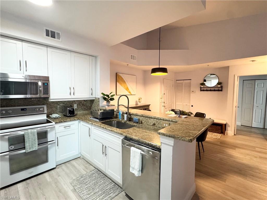 1190 Reserve Way, Unit 304 Naples, FL 34105 - Photo 7 of 20 a kitchen with stainless steel appliances granite countertop a sink stove and cabinets