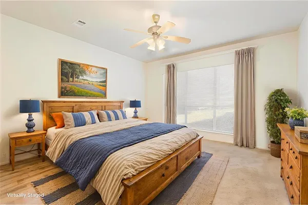 a spacious bedroom with a large bed and a chandelier