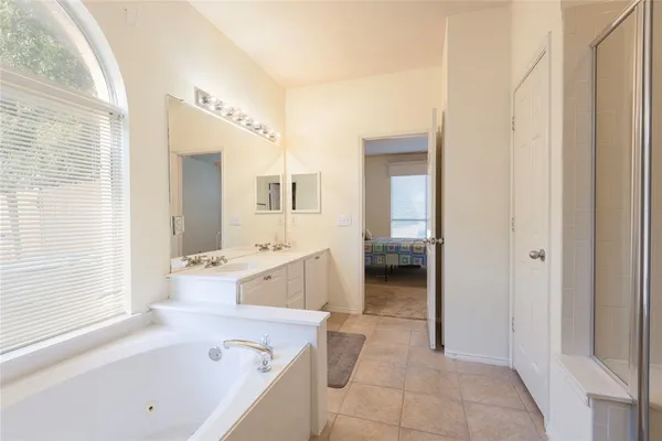 a bathroom with a bathtub sink and mirror