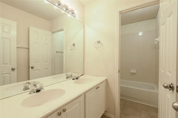 a bathroom with a sink shower and a mirror