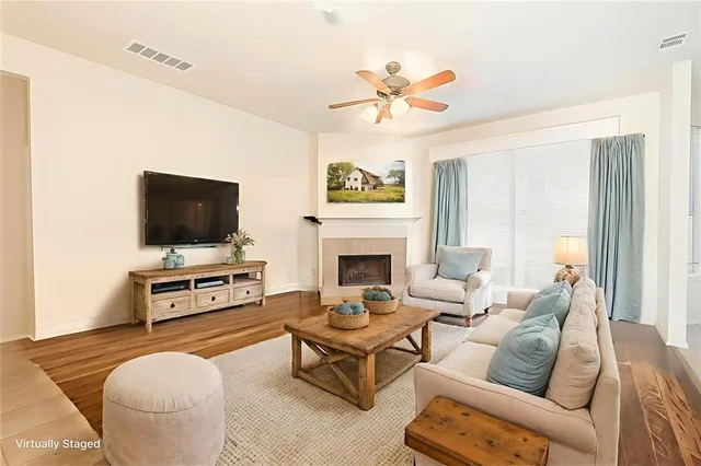 a living room with furniture a flat screen tv and a fireplace
