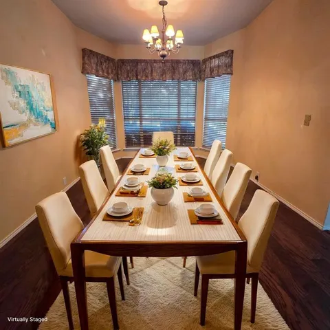 a view of a dining room with furniture a chandelier and wooden floor