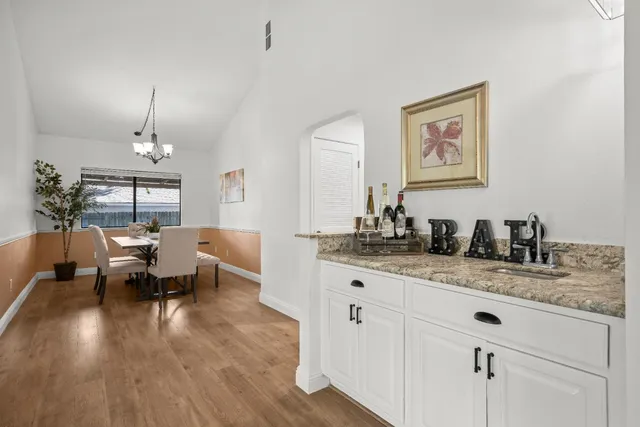 a view of a dining room with furniture a chandelier and wooden floor