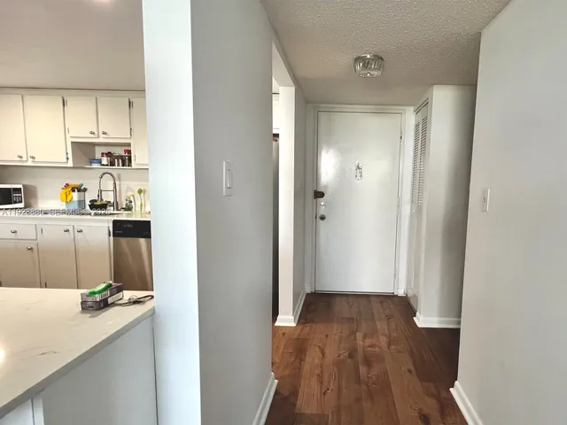 a view of a kitchen with wooden floor and cabinets