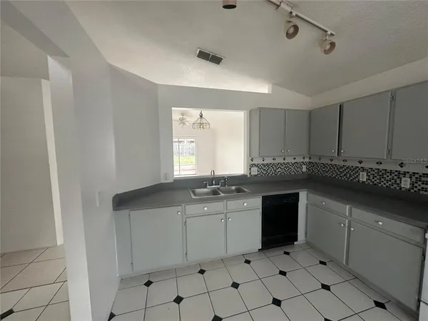 a kitchen with white cabinets and sink