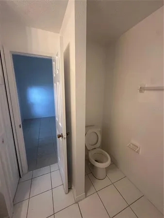 a bathroom with a granite countertop toilet and a sink