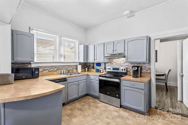 a kitchen with granite countertop a sink a counter top space appliances and cabinets