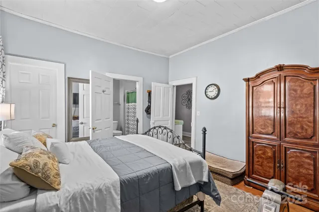 a bedroom with a bed and large windows