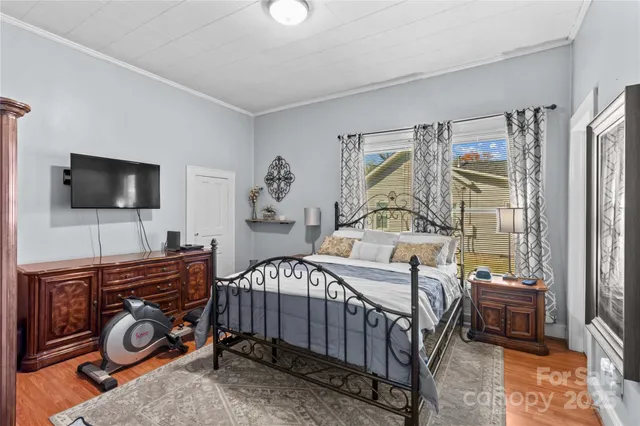a bedroom with a bed and a flat tv screen on the dresser