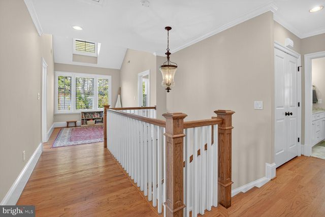 a view of a hallway with wooden floor and windows