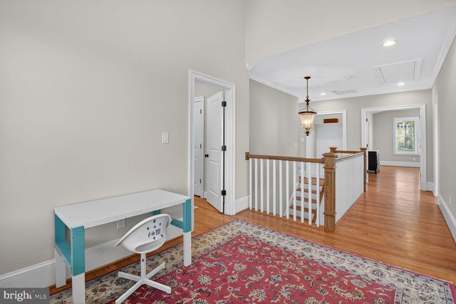 a view of a hallway with wooden floor and cabinet