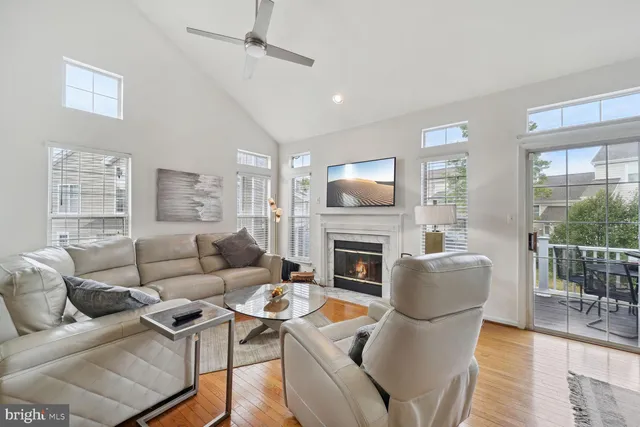 a living room with furniture a fireplace and a floor to ceiling window