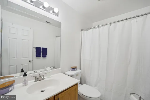 a bathroom with a sink vanity mirror and toilet