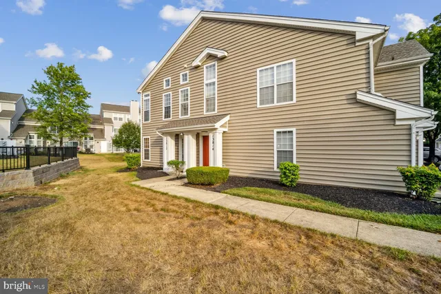 a front view of a house with a yard and potted plants