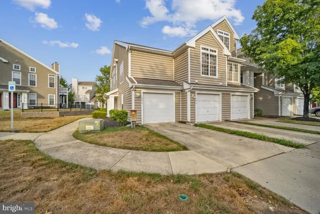 a view of a white house with large windows next to a road