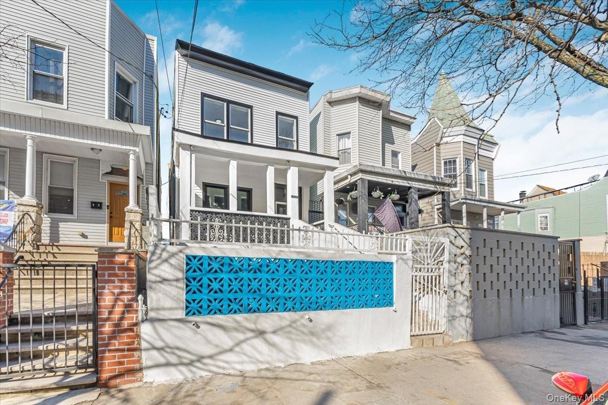 View of front of property with a porch, a gate, and a fenced front yard