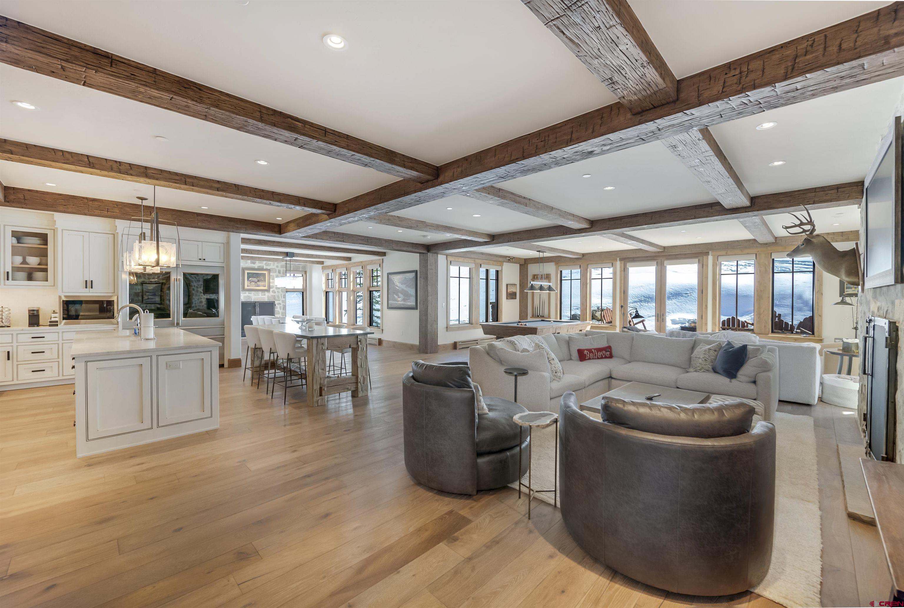 a living room with furniture large window and wooden floor