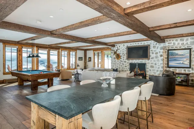 a dining table with chairs and couches with wooden floor