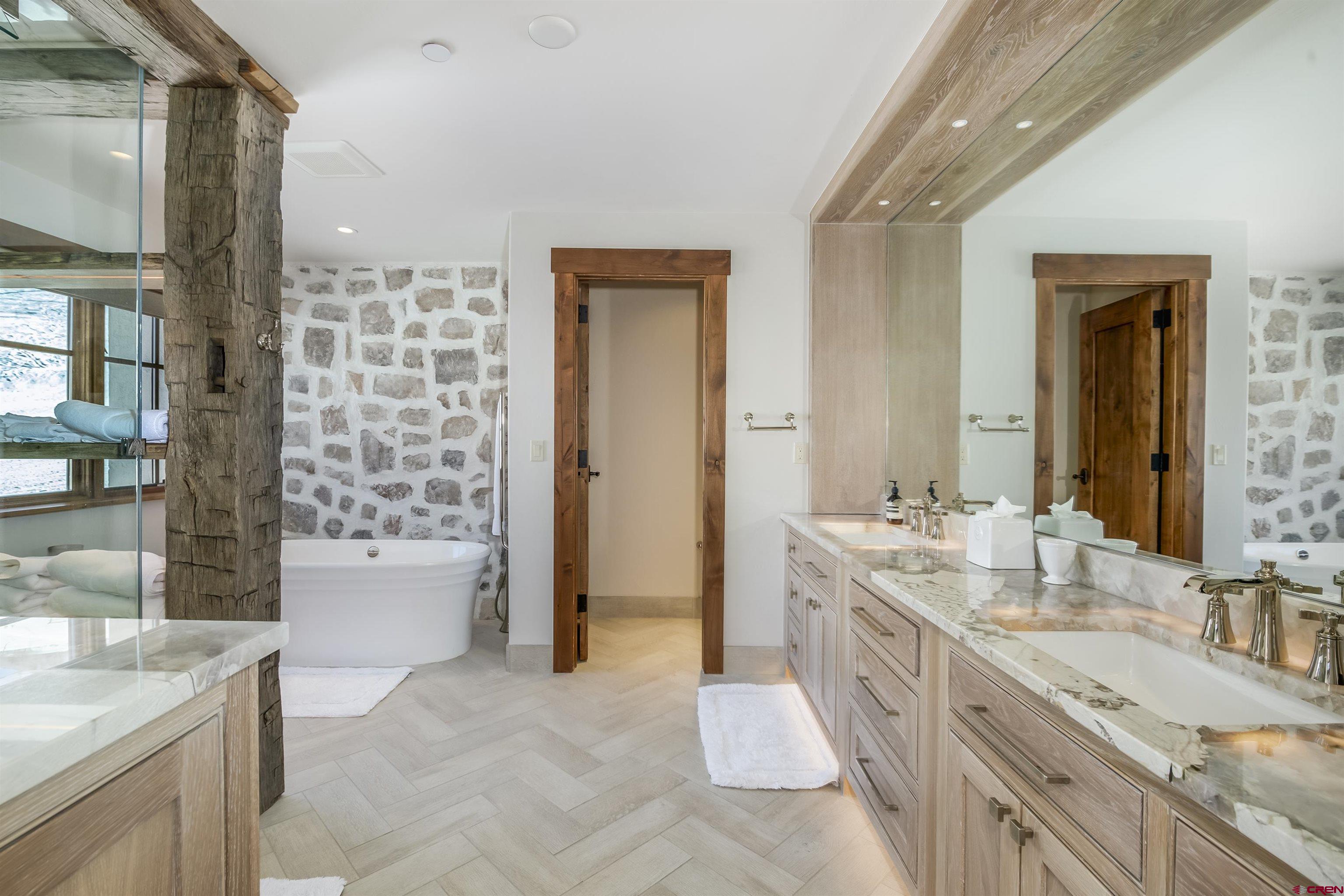 14 Hunter Hill Road, Unit C205 Crested Butte, CO 81225 - Photo 17 of 33 a spacious bathroom with a granite countertop double vanity sink a mirror and a bathtub