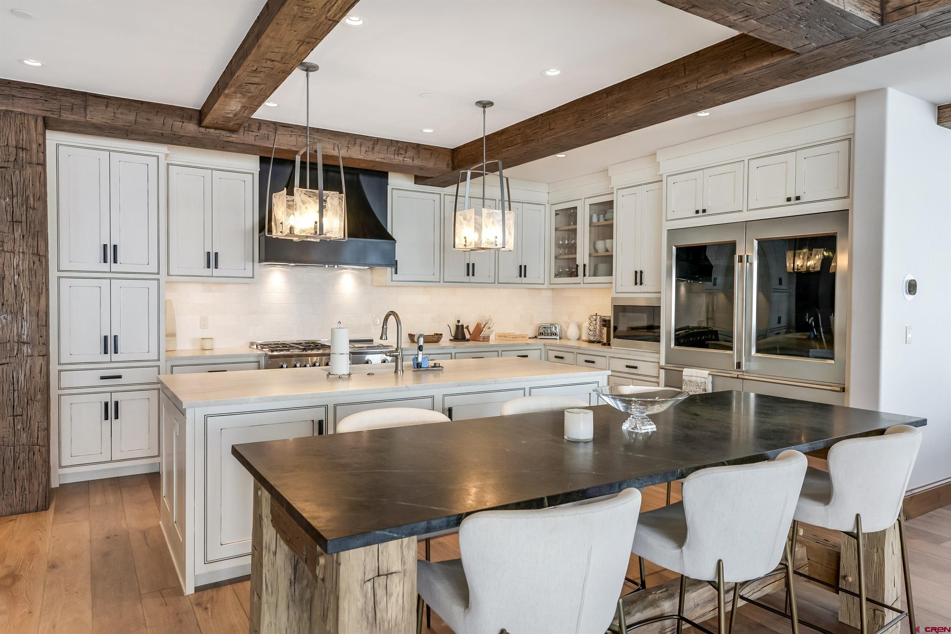 14 Hunter Hill Road, Unit C205 Crested Butte, CO 81225 - Photo 4 of 33 a kitchen with a table chairs stove and wooden floor