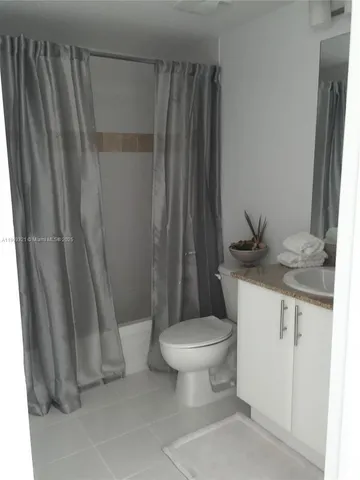 a bathroom with a granite countertop sink toilet and a mirror