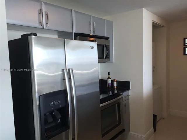a metallic refrigerator freezer sitting in a kitchen