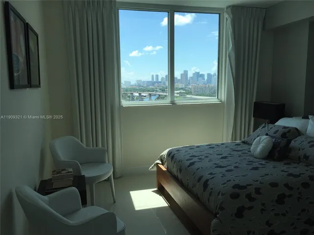 a bedroom with a bed chair and window