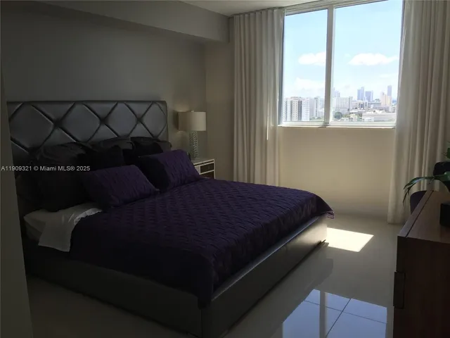 a bed sitting in a bedroom next to a window