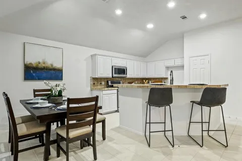 a kitchen with stainless steel appliances kitchen island granite countertop a table and chairs