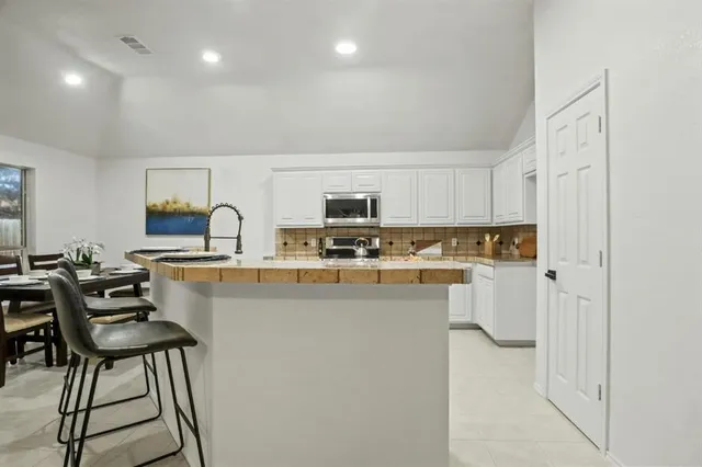 a kitchen with stainless steel appliances a refrigerator and a stove top oven