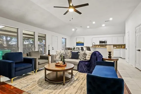 a living room with furniture kitchen view and a large window