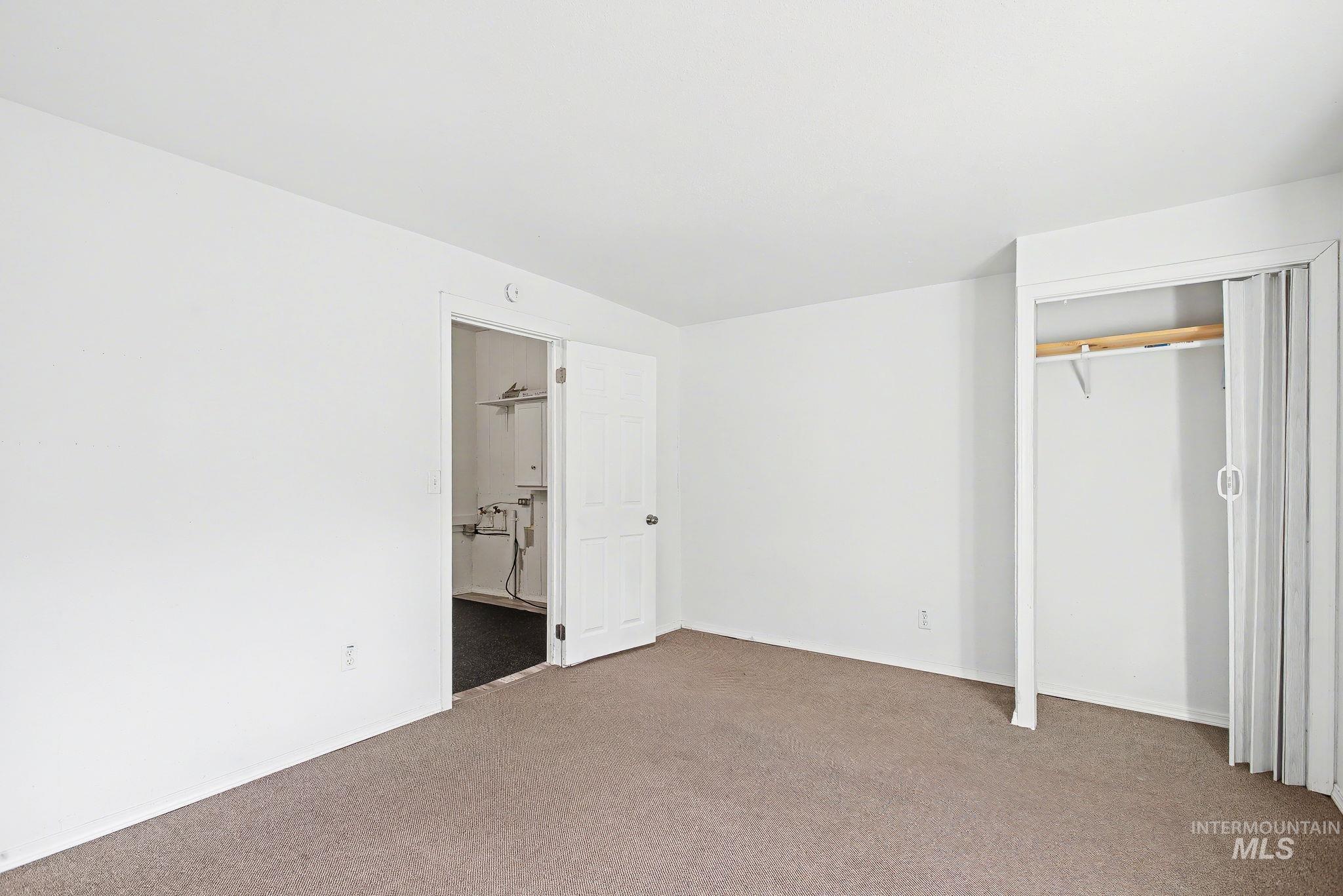 150 Elm Street Orofino, ID 83544 - Photo 22 of 36 Carpeted room with white walls, a bi-fold door closet with wooden rod, and a utility closet with white paneled door
