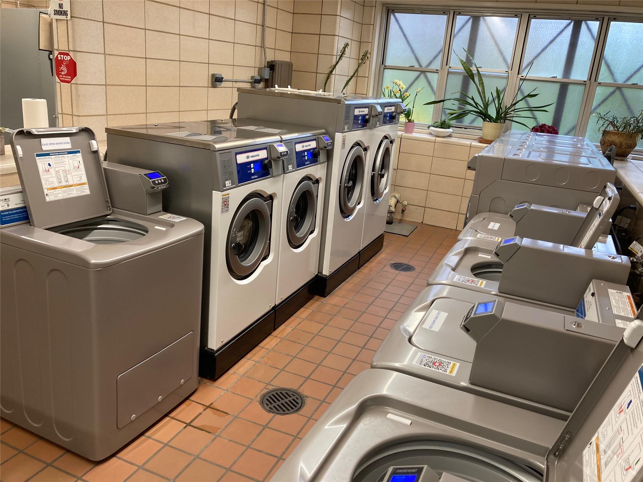 17-85 215th Street, Unit 4B Queens, NY 11360 - Photo 26 of 31 Communal laundry room with washing machine and clothes dryer, light tile patterned floors, and tile walls