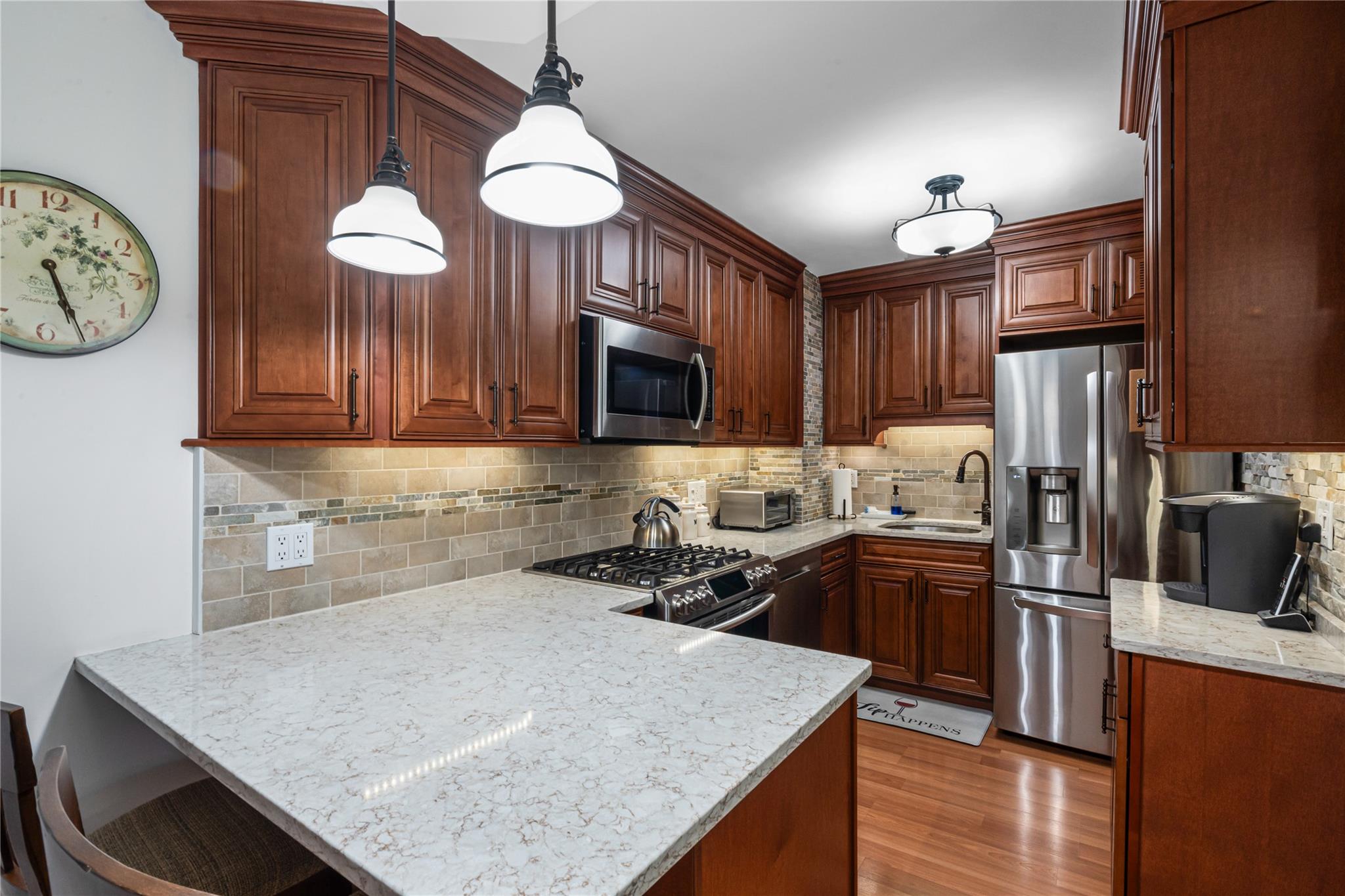 17-85 215th Street, Unit 4B Queens, NY 11360 - Photo 3 of 31 Kitchen with appliances with stainless steel finishes, a sink, a peninsula, and decorative backsplash