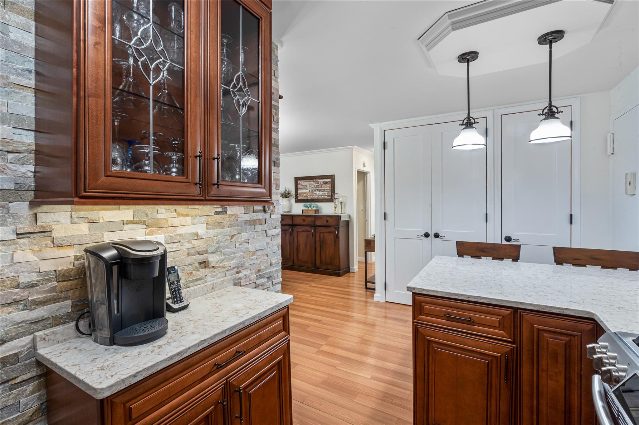 17-85 215th Street, Unit 4B Queens, NY 11360 - Photo 4 of 31 Kitchen featuring stainless steel gas range oven, decorative light fixtures, light stone countertops, ornamental molding, and light wood-style flooring