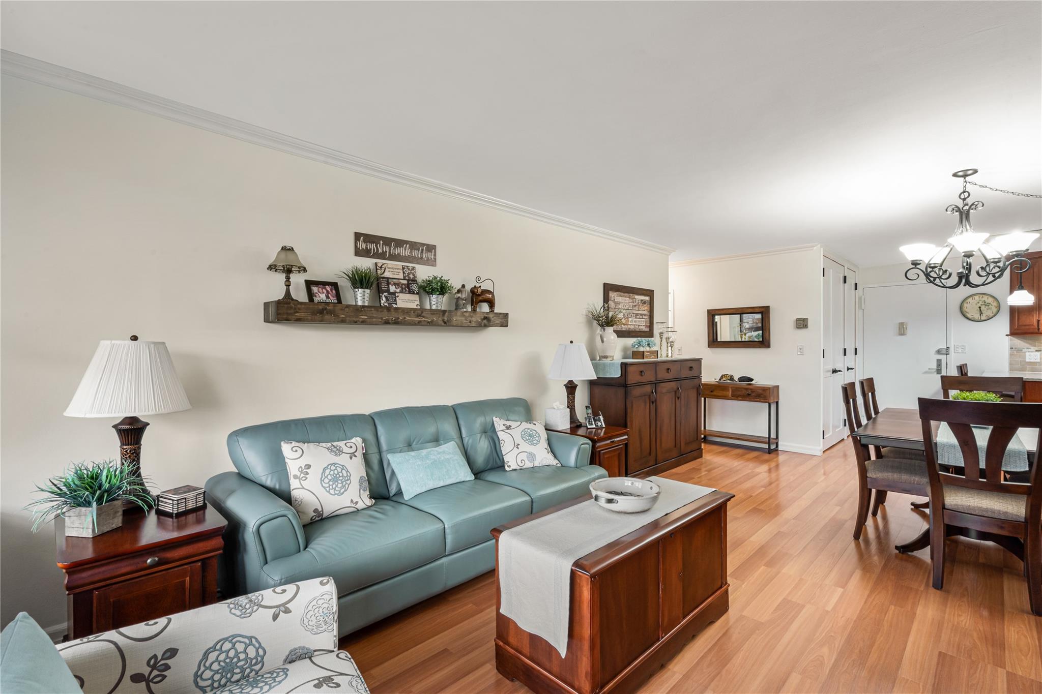 17-85 215th Street, Unit 4B Queens, NY 11360 - Photo 7 of 31 Living area with crown molding, a chandelier, and light wood-type flooring