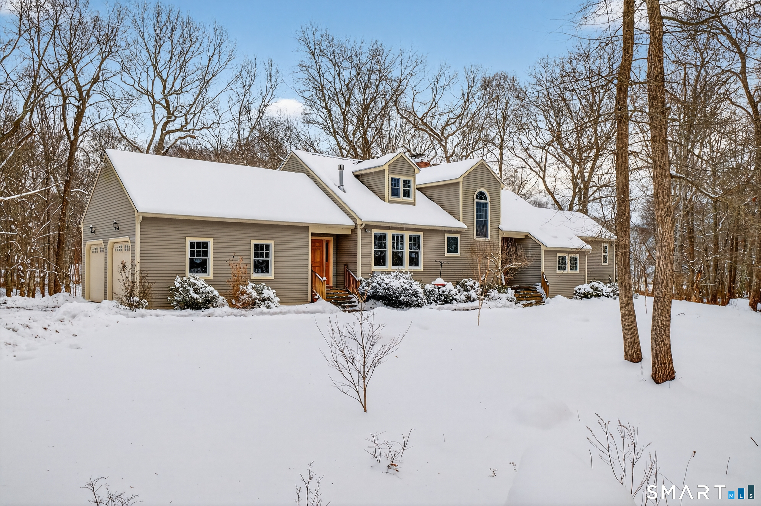 a front view of a house with a yard covered with snow in front of house