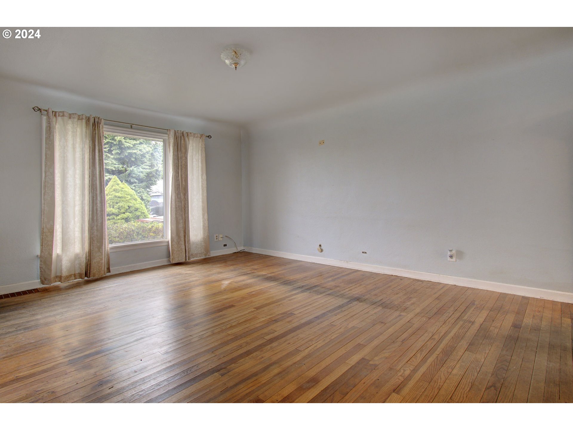 168 Southeast Whitney Street Camas, WA 98607 - Photo 7 of 32 a view of an empty room with wooden floor and a window