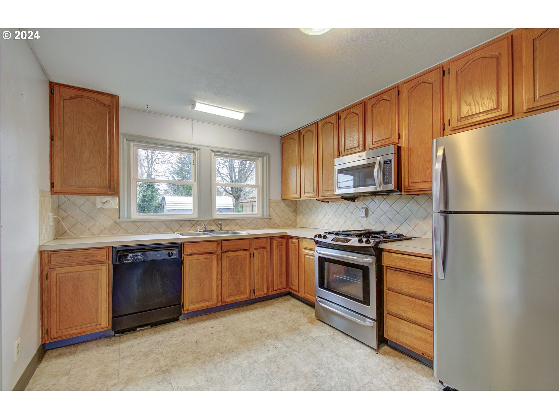 168 Southeast Whitney Street Camas, WA 98607 - Photo 9 of 32 a kitchen with stainless steel appliances granite countertop a refrigerator a stove top oven and a sink with wooden cabinets