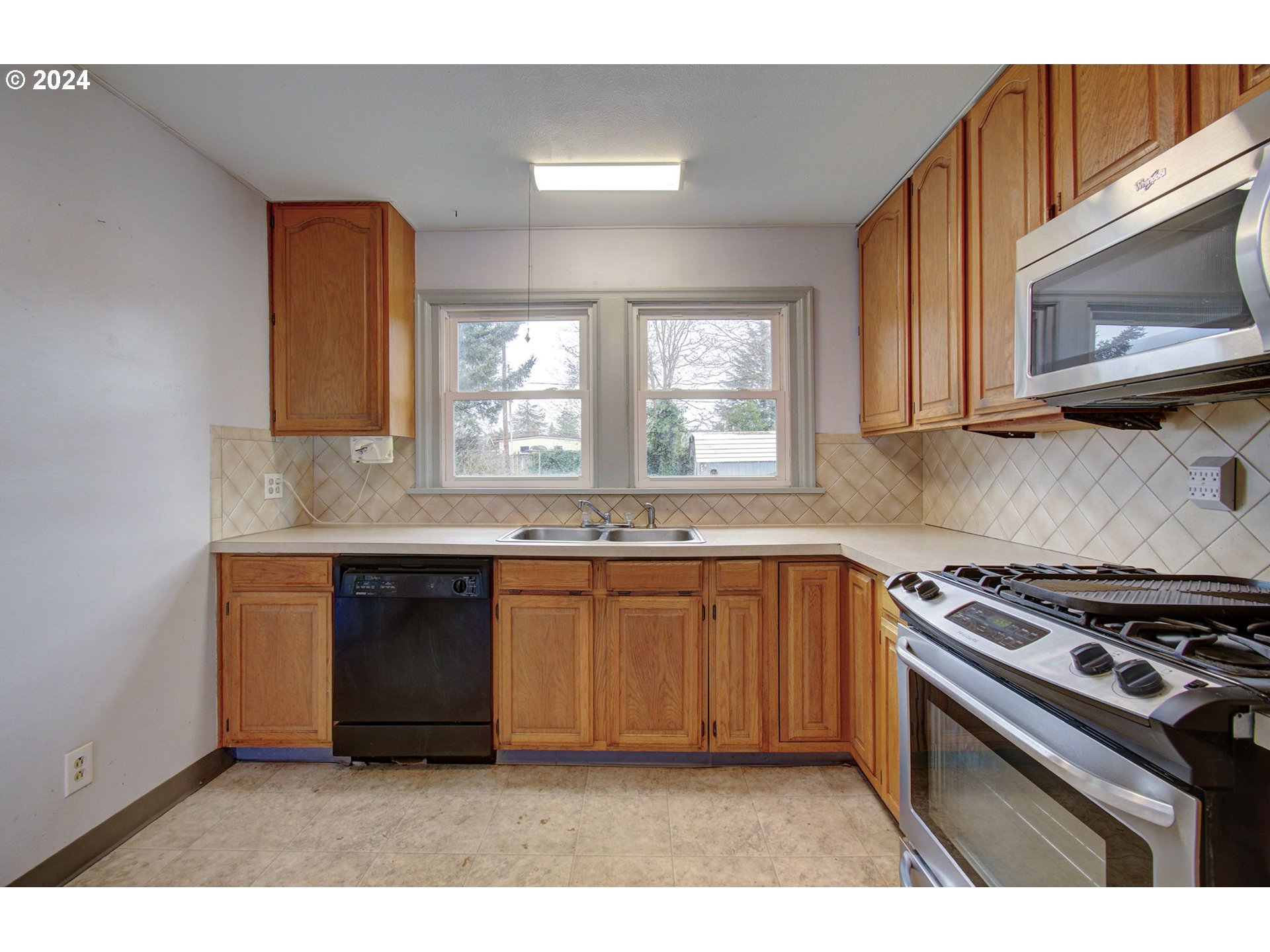 168 Southeast Whitney Street Camas, WA 98607 - Photo 10 of 32 a kitchen with granite countertop a stove a sink and a microwave