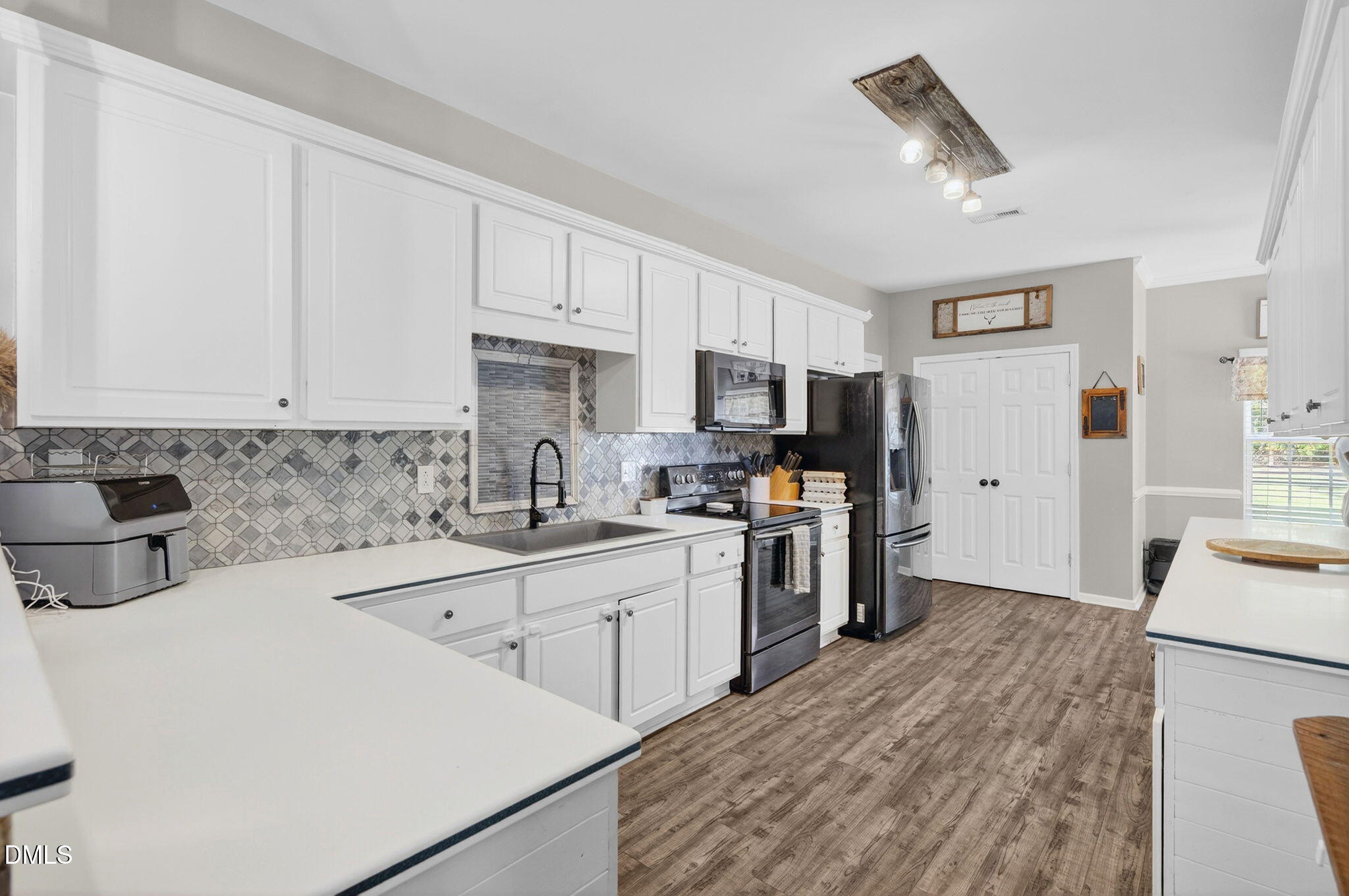 25 Hillside Village Drive Louisburg, NC 27549 - Photo 13 of 35 a kitchen with white cabinets and stainless steel appliances