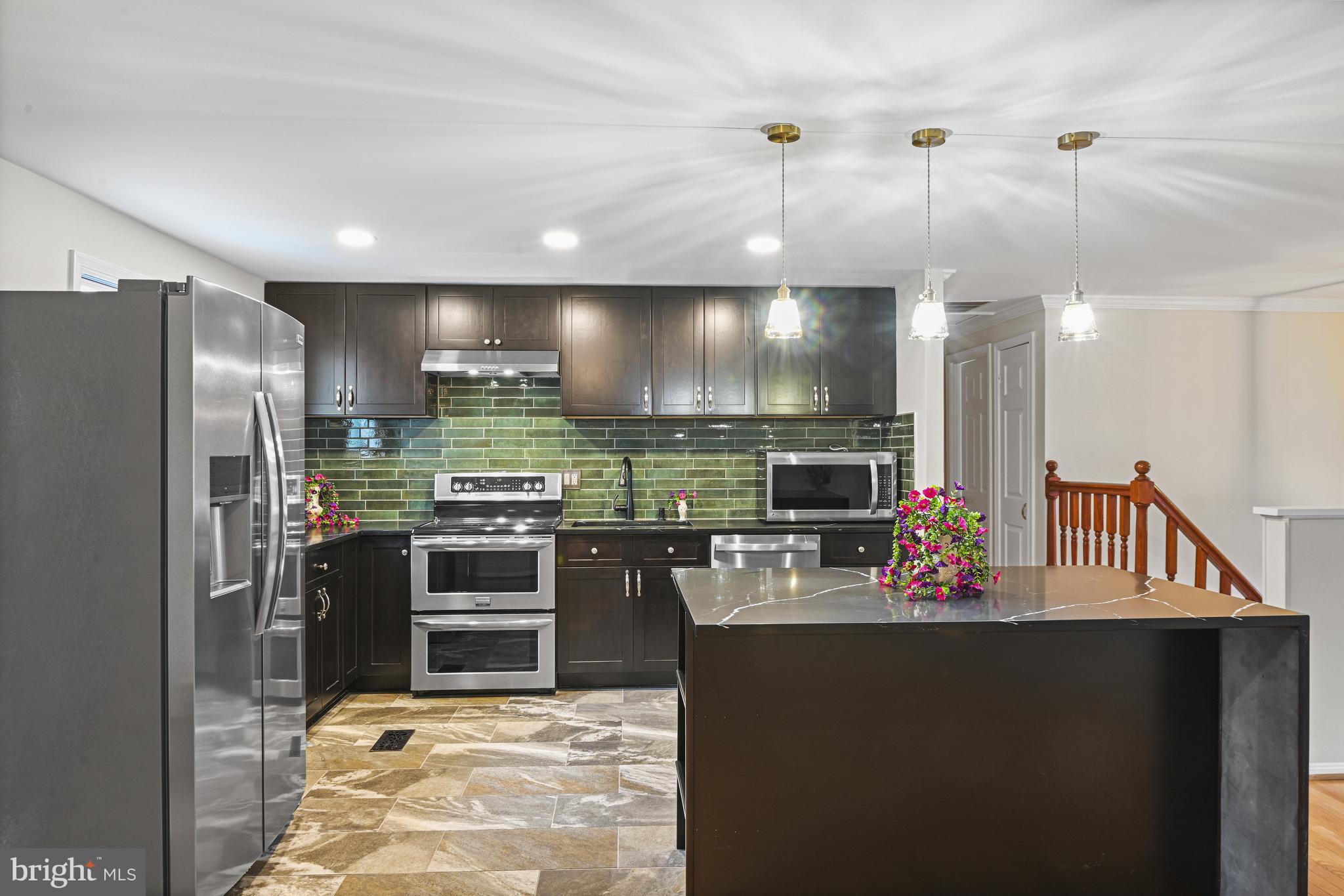 532 Merlins Lane Herndon, VA 20170 - Photo 6 of 42 a kitchen with stainless steel appliances kitchen island granite countertop a refrigerator and a stove top oven