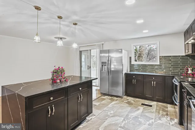 a kitchen with granite countertop a sink cabinets and stainless steel appliances