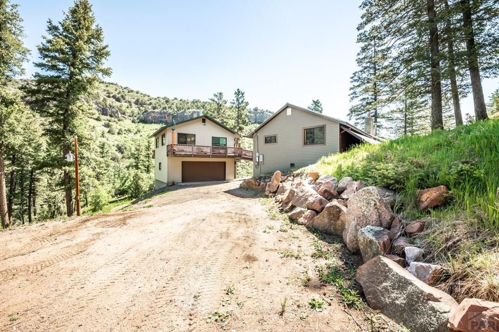 9600 Middle Creek Canyon Road Beulah, CO 81023 - Photo 2 of 50 a front view of a house with a yard and garage