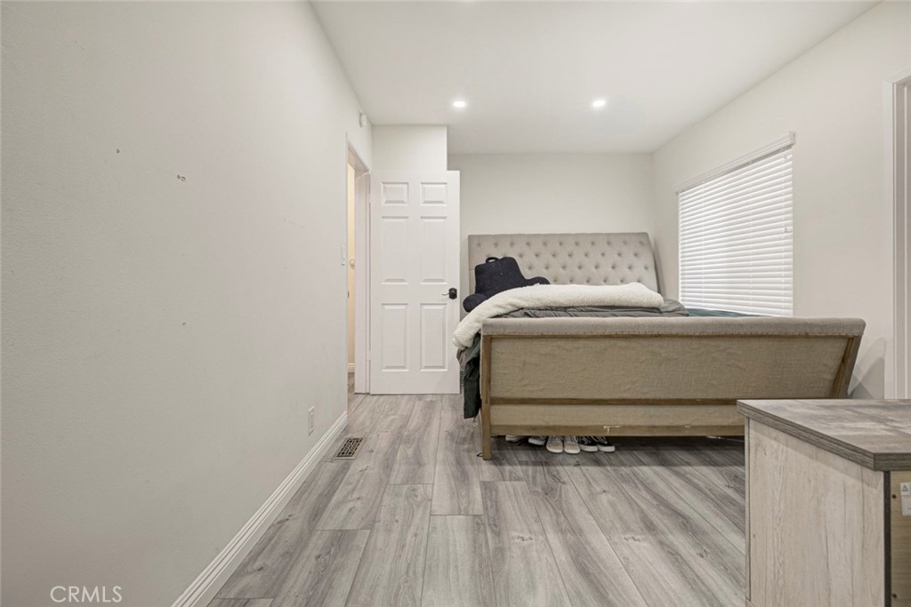 10317 Pinyon Avenue Tujunga, CA 91042 - Photo 39 of 41 a bedroom with a bed and a wooden floor
