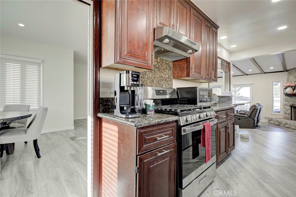 10317 Pinyon Avenue Tujunga, CA 91042 - Photo 10 of 41 a kitchen with stainless steel appliances granite countertop a stove top oven a sink dishwasher and cabinets with wooden floor