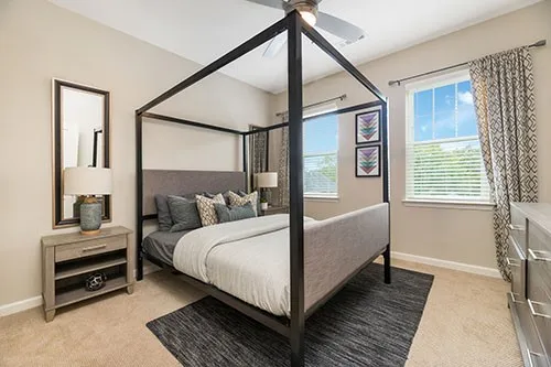 a bedroom with a bed wooden floor and window