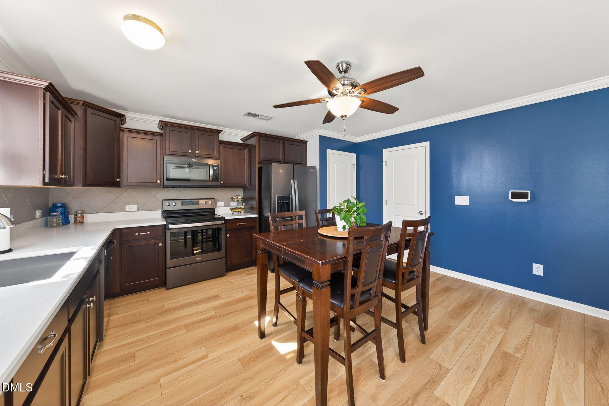 509 Houndstooth Lane Wendell, NC 27591 - Photo 9 of 33 a kitchen with stainless steel appliances kitchen island granite countertop a sink a stove a dining table and chairs with wooden floor