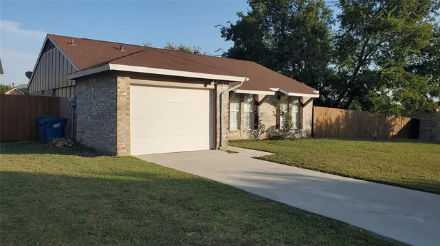 a front view of a house with a garden and yard