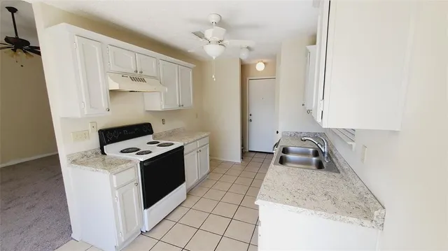 a view of an empty room with closet and a chandelier fan